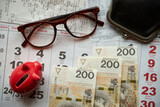 Fototapeta  - paragony fiskalne , polskie banknoty , kartka z kalendarza, świnka skarbonka, emerytura	