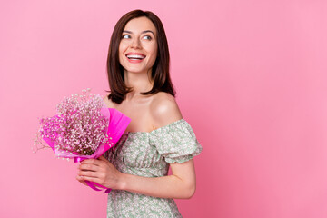 Poster - Photo of adorable thoughtful lady wear green clothes smiling looking empty space holding baby breath flower isolated pink color background