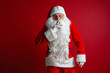 © ZaStock - Santa Claus keeping forefinger by his mouth and looking at camera. Christmas and New Year's concept