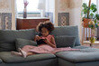 © KAMPUS - Concentrated little girl reading electronic book. African American girl with curly hair, looking at electronic book or tablet. Education, leisure, technology concept