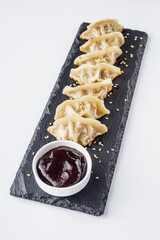 delicious fried gyoza dumplings on a black plate