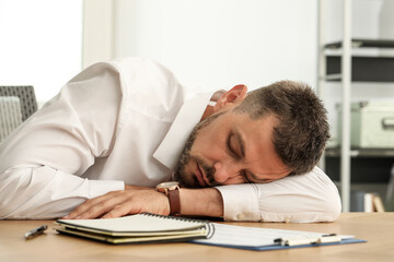 Canvas Print - Tired man sleeping at workplace in office