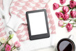 E-book reader cardigan, flowers and cup of tea on white wooden table, flat lay. Space for text