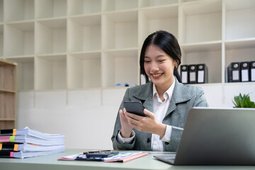 Wall Mural - Beautiful young business woman using phone in office