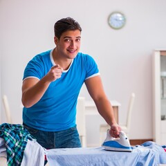 Wall Mural - Man husband ironing at home helping his wife