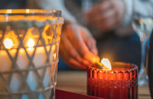 Close-up Shot Of A Woman's Hand Lighting A Candle Using Matches