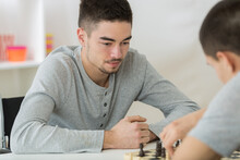 Portrait Of Two Young Man Playing Chess