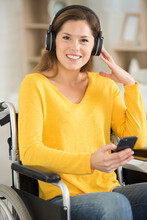 Happy Woman In A Wheelchair With Headphones