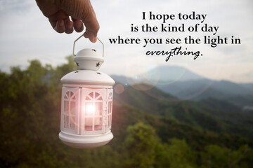 Life inspirational and motivational quote - I hope today is the kind of day where you see the light in everything. With person carry white lantern light in hand on mountain background. Positive words.