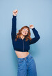 © Jacob Lund - Happy young woman dancing and having fun while wearing a crop top and jeans in a studio
