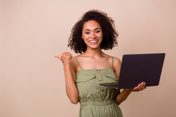 Poster - Photo of boss brunette woman index promo hold laptop wear khaki overall isolated on beige color background