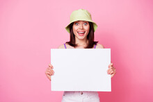 Photo Portrait Of Excited Lovely Young Lady Holding Blank Board Copyspace Ad Dressed Trendy Singlet Cap Isolated On Pink Color Background