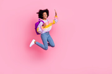 Poster - Full length photo of sweet excited little child dressed pastel pullover jumping high waving arm empty space isolated pink color background