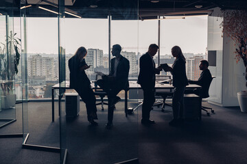 Silhouette photo of businesspeople during working day in modern meeting room