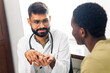 © yurakrasil - Indian doctor therapist in white coat consulting supporting patient in modern clinic hospital