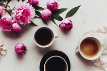  Two Cups Of Coffee And Pink Flowers On A Marble Table Top With A White Cloth And A White Towel.
