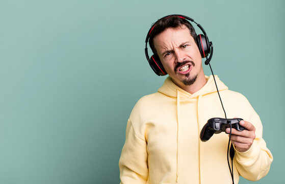 adult man feeling puzzled and confused with headset and a control. gamer concept