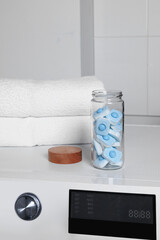 Canvas Print - Glass jar with water softener tablets on washing machine in bathroom