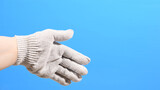 Fototapeta Boho - Hand in a working construction cotton glove on a blue background. High quality photo