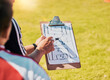 © L Ismail/peopleimages.com - Clipboard, game planning and on field for soccer, sports and outdoor for competition with coach. Football, strategy and communication for instructions, talking and paper for match day formation.
