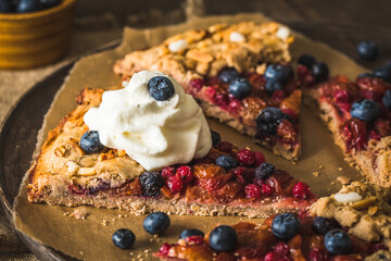 Wall Mural - Berry galette with fresh blueberries and whipped cream on a rustic wooden table