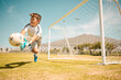 © L Ismail/peopleimages.com - Football, boy goalkeeper and jump, saving ball from goals at outdoor sports field. Soccer, kid and competition game with fitness, goal keeper and soccer ball on grass, success and action to save goal