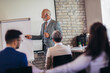 © Mediteraneo - Speaker at business workshop entrepreneur giving a presentation about business to colleagues in the office.