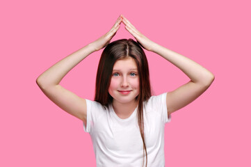 Wall Mural - Smiling teen girl making roof upon her head with hands