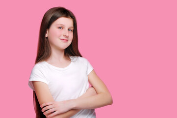 Wall Mural - Smiling teen girl with crossed hands against pink background