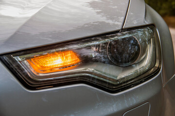 Yellow car emergency lights on the headlight closeup	
