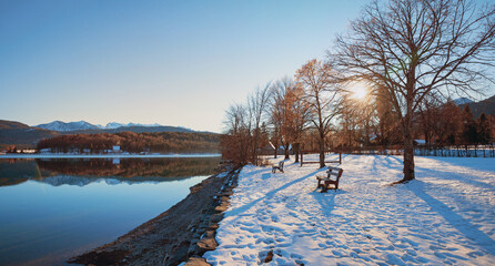 Wall Mural - winter evening scenery, snowy lake shore Walchensee, recreational area with benches