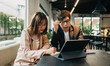 © Nuttapong punna - Two Asian businesswoman discuss investment project working and planning strategy with tablet laptop computer in modern office..