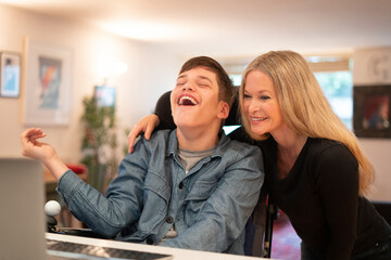 Mother and disabled son using laptop