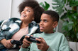 © Cultura Creative - Mother and son playing video games at home