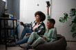 © Cultura Creative - Mother and son playing video games at home