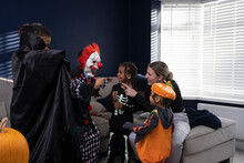 Smiling Family In Halloween Costumes At Home