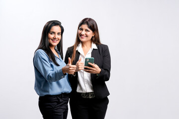 Canvas Print - Two young indian business woman or employee showing thumps up on white background.