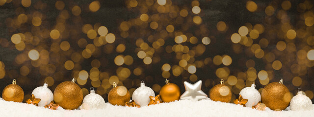 Wall Mural - Festive ornaments advent celebration holiday holidays banner greeting card panorama long - Many golden and white baubles, christmas balls on snow, with black concrete wall and bokeh lights background