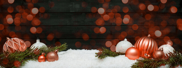 Wall Mural - Festive christmas ornaments advent celebration holiday holidays banner greeting card -Orange white christmas baubles, christmas balls and pine branches on snow, with black wooden wall in background