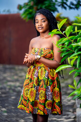 posed image of beautiful african woman in a garden- black lady in local traditional dress- fashion concept