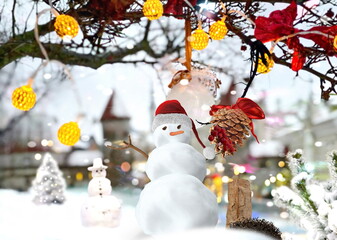 Wall Mural - Christmas snow man in red santa hat and holiday  trees decoration on street Tallinn Old town  snowy weather travel to Estonia Europe