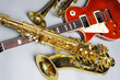 Electric guitar, trumpet and golden saxophone on a light background.