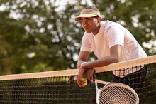 Young Man In Sun Visor At The Tennis Courts