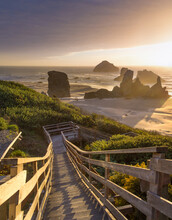 Wooden Steps Down To Beach At Sunset On The Oregon Coast.  Bandon Beach. Sea Stacks And Waves Crashing