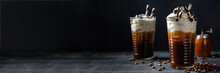Cold Coffee Drink Frappe (frappuccino), With Whipped Cream And Chocolate Syrup, With Straws, Coffee Beans On A Dark Gray Stone Table, Copy Space 