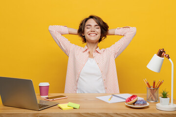 Wall Mural - Young employee business woman in casual shirt sit work at white office desk with pc laptop hold hands behind neck take break rest relax isolated on plain yellow background Achievement career concept