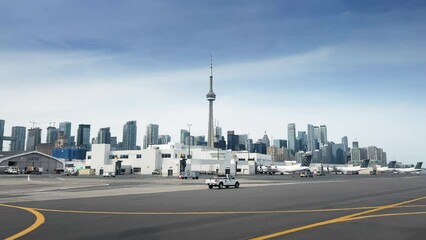 Wall Mural - CN tower with modern high rise buildings viewed from airport against blue sky