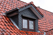 House with bicolor roof tiles and dormer with gray shingles