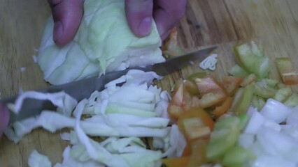 Wall Mural - an amateur cook cuts cabbage on a cutting board, close-up