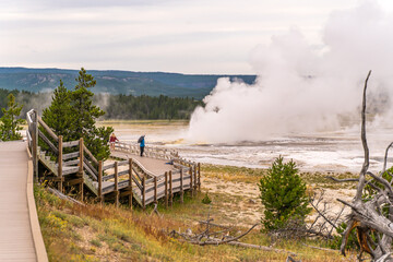 Canvas Print - Tourists watching the Clepsydra geyser on the Fountain Paint Pot Trail in Yellowstone National Park.